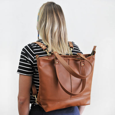 Woman wearing recycled leather convertible Mariana backpack and crossbody bag
