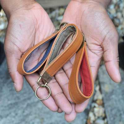 Hands holding Recycled leather keychains with wax canvas interior