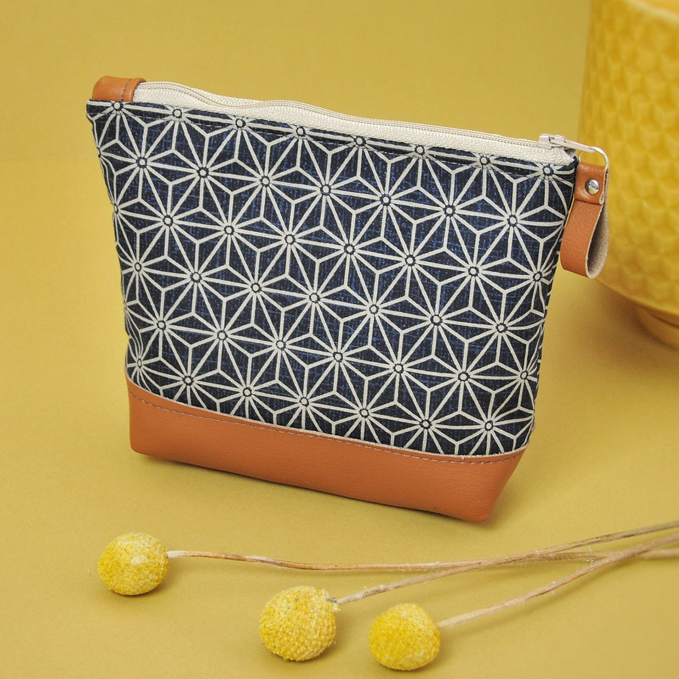 Recycled leather make up bag on yellow background