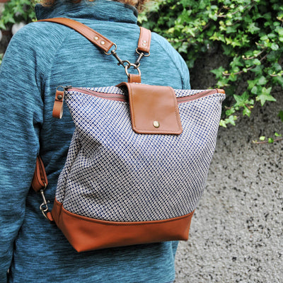 Recycled leather convertible backpack being worn on model