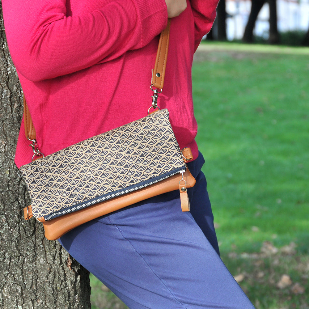 Model wearing recycled leather fold over bag