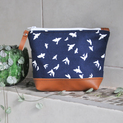 Recycled leather make up bag in navy bird cotton fabric in bathroom setting