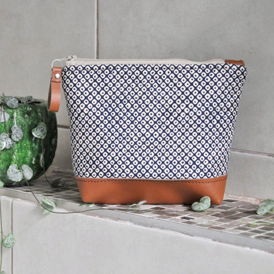 Recycled leather make up bags in navy shibori cotton fabric in bathroom setting
