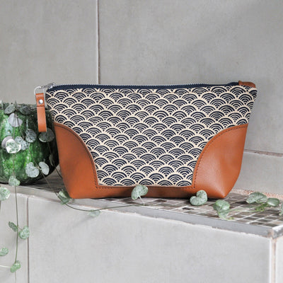 Recycled leather toiletry bag in blue Japanese wave fabric in bathroom setting