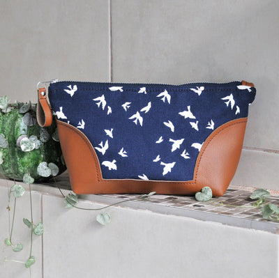Recycled leather toiletry bag in navy bird fabric bathroom setting