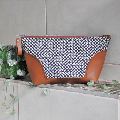 Recycled leather toiletry bag in navy shibori in bathroom setting