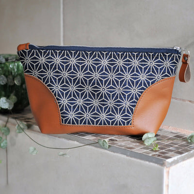 Recycled leather toiletry bag in navy asanoha fabric in bathroom setting