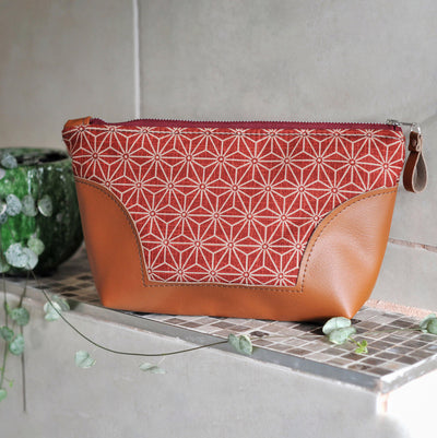 Recycled leather toiletry bag in red asanoha fabric in bathroom setting