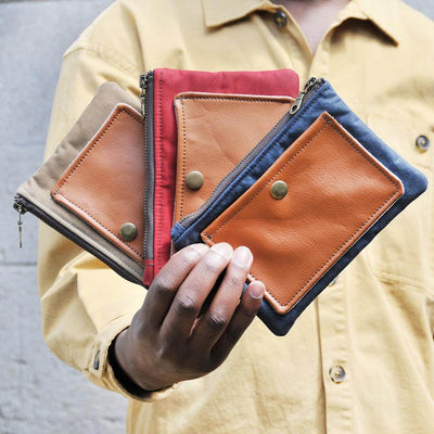 Man holding recycled leather travel pouches