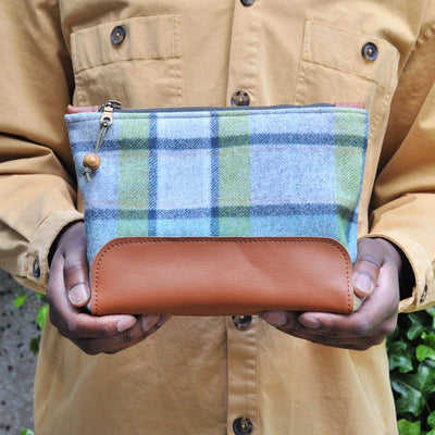 Hands holding green woollen recycled leather washbag 